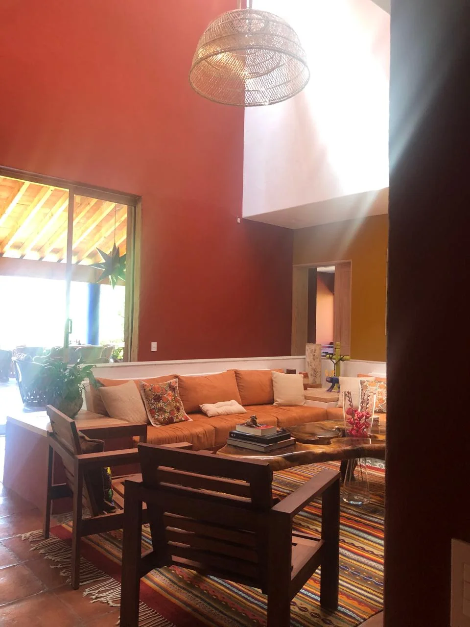Sala y comedor integrados en un interior de tonos rojos